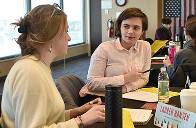 Photo: Two Seeds students are seated at a work table, engaged in a negotiation exercise.